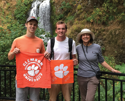Oregon Adam Rourke ’14, Dawson Powers ’11 and Annemarie Havenga Jacques ’76, M ’81 show their Tiger Rags at Multnomah Falls, along the Columbia River Gorge.