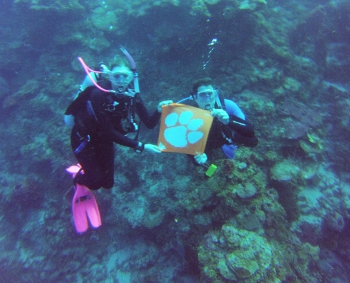 Honduras: Siblings Nick ’14 and Alyssa ’17 James scuba dive 60 feet underwater with their Tiger Rag in Roatan.