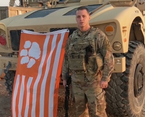 Syria: Hayes McDowell ’14, a first lieutenant serving as base commander in Syria during a 10-month tour under Operation Inherent Resolve, showed off his love for Clemson before the Military Appreciation Game against Duke in 2018.